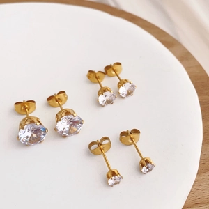 Sparkling zircon stud earrings set in gold titanium steel with classic four-prong setting