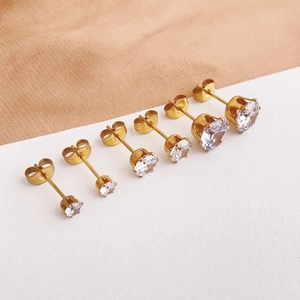 Macro shot of six sizes of gold titanium steel stud earrings with round cubic zirconia stones