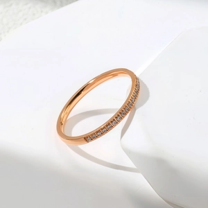 Détail d'un bracelet jonc en or rose avec une rangée élégante de zircons sur pierre