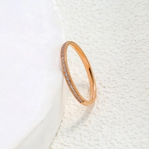 Gros plan d'une bague élégante en acier titane rose doré avec une rangée de zircons blancs