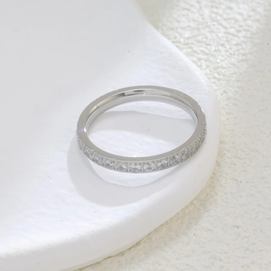 Detailed view of silver stainless steel eternity ring with cubic zirconia on a white tray