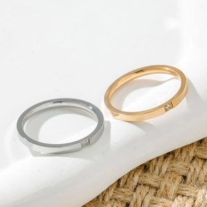 Macro detail of silver and gold minimalist thin bands with a tiny embedded diamond