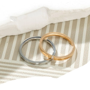 Detail of minimalist thin rings set in silver and rose gold with tiny square zirconia