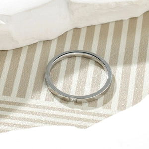 Top view of a minimalist silver titanium steel ring with a square-cut sparkling gemstone