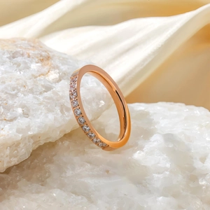 Vue macro d'une fine bague en or rose sertie d'une rangée de zircons étincelants