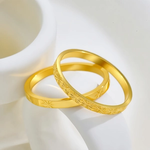 Set de dos anillos de acero de titanio dorado con grabados de estrellas y acabado pulido