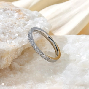Détail macro d'une bague en acier titane argenté sertie de dix zircons étincelants