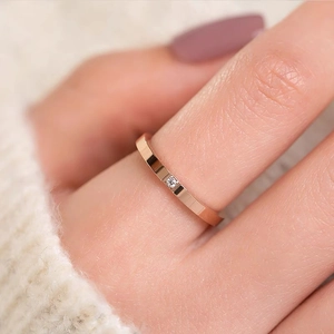 Minimalist rose gold titanium ring with a square zircon worn on finger as fashion jewelry