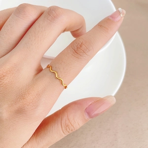 Minimalistischer wellenförmiger Ring aus Roségold-Edelstahl an einer Modellhand gezeigt