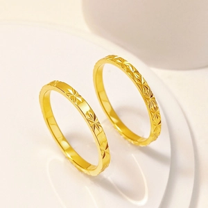 Primer plano detallado de anillos de acero de titanio dorado con grabados de estrellas