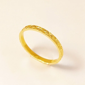 Detalle de anillo de acero de titanio dorado con textura de corte de diamante y acabado pulido