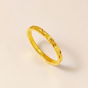 Detalle de anillo de acero de titanio dorado con grabados de estrellas finos
