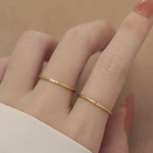 Minimalist gold rings set with cubic zirconia stones worn by a hand for elegant styling