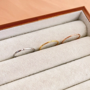 Detailed close-up of three minimalist thin band rings in silver, gold, and rose gold finishes