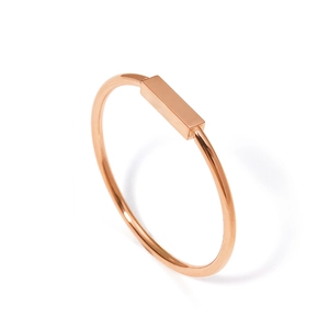 Detalle macro de un anillo minimalista de oro rosa de 18K con barra rectangular pulida