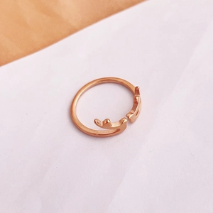 Dettaglio dell'anello regolabile in oro rosa con design a corna di cervo minimalista