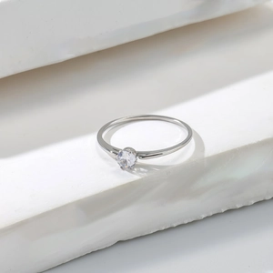 Macro shot of silver ring featuring a classic round-cut diamond in a four-prong setting