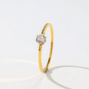 Detailed view of elegant gold ring with six-prong set solitaire diamond on white background