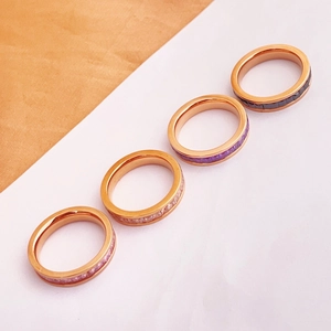 Detail view of four rose gold rings set with square-cut black, purple, white, and pink crystals