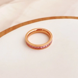 Macro detail of rose gold band featuring pink princess-cut zircon stones in a row