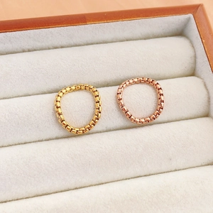 Set aus Gold- und Roségold-Box-Chain-Ringen auf einem Schmuckkasten-Präsentationskissen