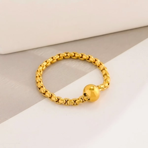 Detaillierte Nahaufnahme eines goldenen Box-Chain-Armbands mit poliertem Kugelanhänger