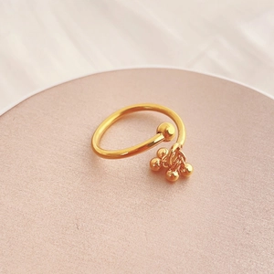 Minimalist gold titanium steel open ring featuring a large bead and four hanging charms