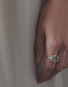 Détail macro d'une bague en argent ornée d'une grande pierre transparente en cœur