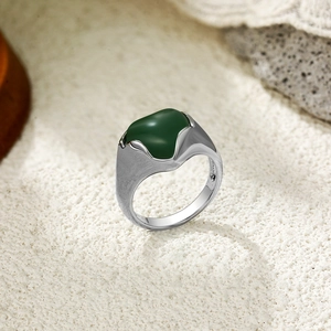 Détail d'une bague en métal brossé argenté avec une grande pierre d'agate verte