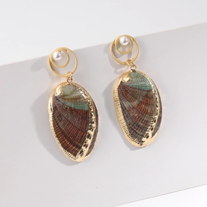 Detail of mermaid beach shell earrings with golden metal rings and abalone shell pendants