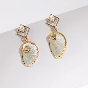 Golden geometric earrings with white pearls and iridescent shell charms for beach vacations
