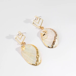 Detailed close-up of shell drop earrings with iridescent luster and gold-plated edges