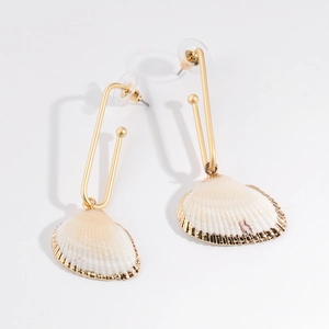 Detailed shot of bohemian sea shell drop earrings with golden trim on white backdrop