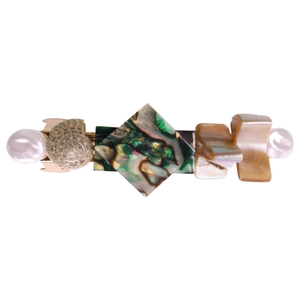 Detail of golden hair clip with natural seashell, abalone texture, and pearls inlay