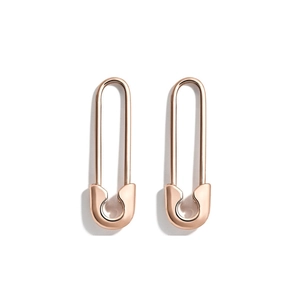 Detailed macro view of gold-plated safety pin earrings with sparkling zircon micro-paving