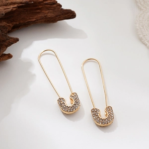 Detail of gold safety pin earrings with micro-paved sparkling cubic zirconia crystals