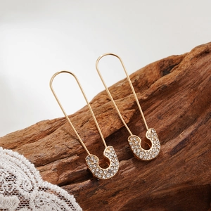 Detailed close-up of gold plated safety pin earrings with micro-pave cubic zirconia crystals