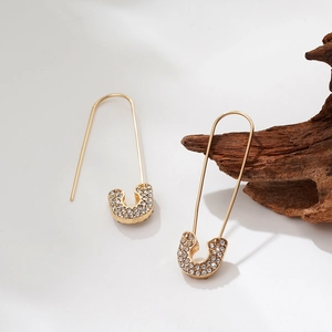 Macro detail of gold-plated paperclip earrings with micro-pave white zircons