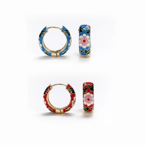 Detailed close-up of retro enamel hoop earrings with colorful floral patterns and gold trim