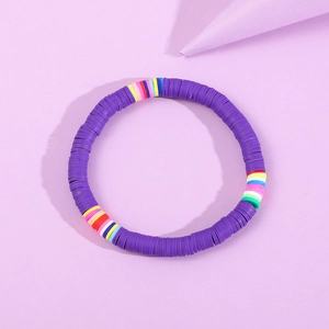 Nahaufnahme des lila Heishi-Armbands aus Polymer-Ton mit regenbogenfarbenem Mittelteil