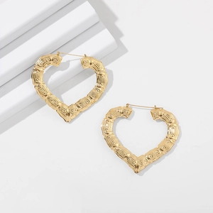 Detail view of 14K gold bamboo style heart-shaped hoop earrings with hinged closure