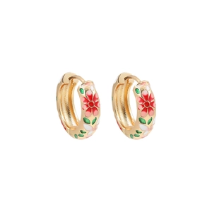 Close-up of golden hoop earrings featuring red enamel flowers and green leaf patterns