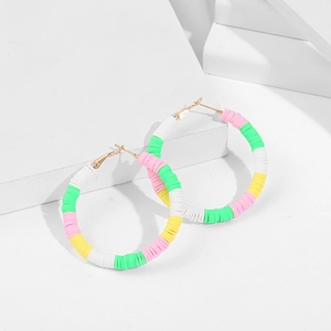 Close-up of rainbow heishi bead hoop earrings on white stone props for a beach style
