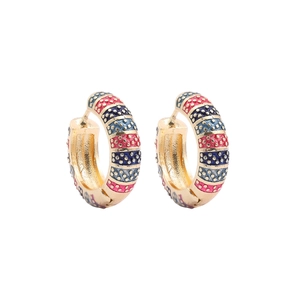 Detail of gold hoop earrings with colorful enamel stripes and embossed gold dot texture