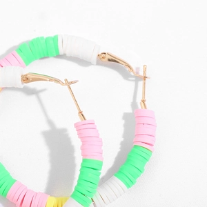 Macro detail of Bohemian C-shape hoop earrings with colorful polymer clay heishi beads
