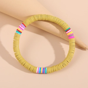 Makro-Detail des senfgelben Heishi-Perlenarmbands mit lebhaften bunten Akzenten