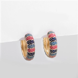 Detailed macro view of retro enamel floral hoop earrings with colorful textured gold finish