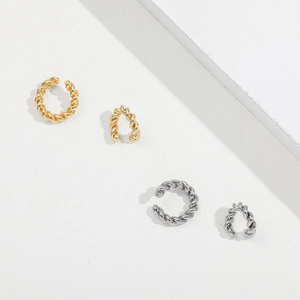 Detail view of twisted C-shape ear cuffs in gold and silver finishes for non-pierced ears