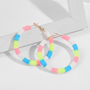 Macro shot of colorful bohemian C-shaped hoop earrings with bright polymer clay beads