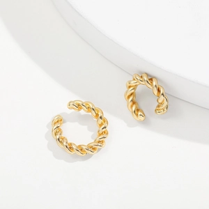 Minimalist golden twisted rope C-shaped ear cuffs set on white geometric steps